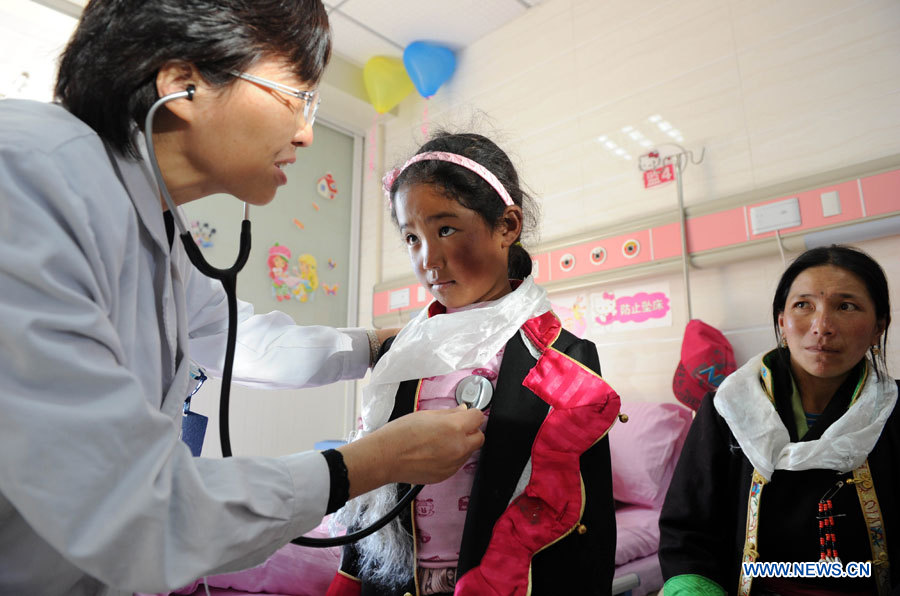 Une fillette tibétaine, qui souffre d'une maladie cardiaque congénitale (MCC), est auscultée par un médecin à l'Hôpital des Enfants de la province de l'Anhui à Hefei, le 5 novembre 2012. Un total de 22 enfants tibétains atteints de cardiopathie congénitale sont arrivés lundi à Hefei pour recevoir des traitements médicaux gratuits.