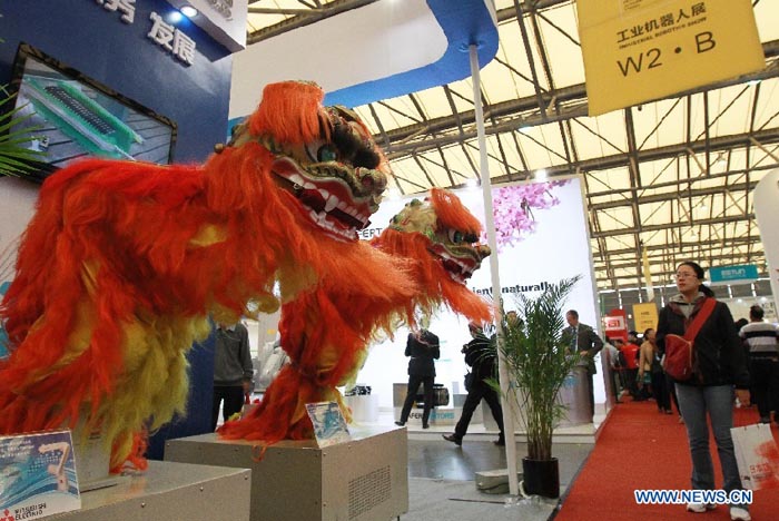 Deux robots industriels donnent une représentation de danse du lion lors de la Foire internationale de l'industrie de Chine à Shanghai (est), le 6 novembre 2012. La foire de cinq jours, ouverte mardi, se déroule annuellement en novembre depuis 1999.