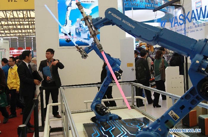 Des visiteurs regardent deux robots réalisant un combat de sabres lors de la Foire internationale de l'industrie de Chine à Shanghai (est), le 6 novembre 2012. La foire de cinq jours, ouverte mardi, se déroule annuellement en novembre depuis 1999.