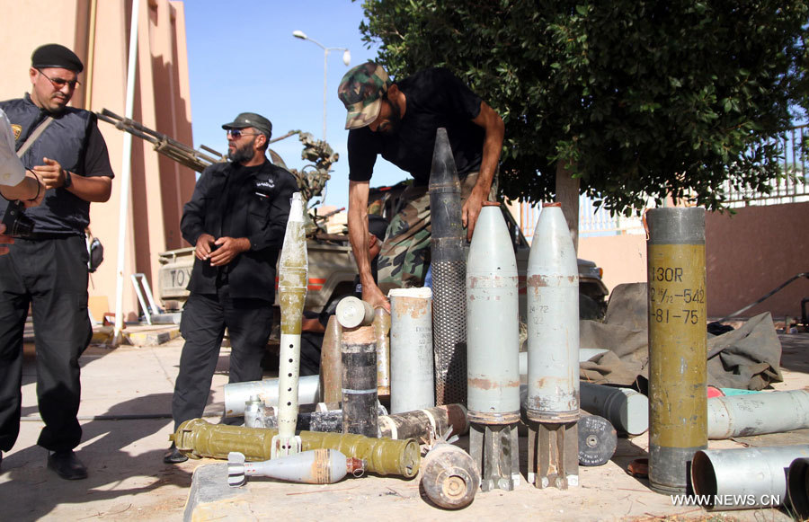 Des membres du ministère libyen de l'Intérieur ramassent des munitions retrouvées à Bani Walid en Libye, le 10 novembre, soit 15 jours après la fin d'une opération militaire. Des centaines de Libyens et de travailleurs étrangers ont fui la ville le mois dernier, l'un des derniers bastions du régime de l'ancien dirigeant Mouammar Kadhafi.