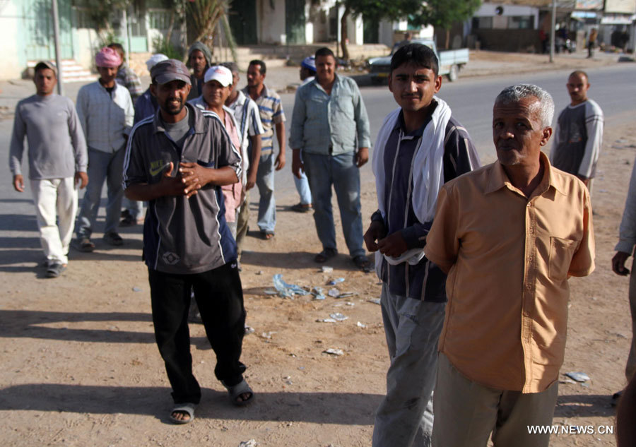 Des ouvriers étrangers attendent un emploi, à Bani Walid en Libye, le 10 novembre, soit 15 jours après la fin d'une opération militaire. Des centaines de Libyens et de travailleurs étrangers ont fui la ville le mois dernier, l'un des derniers bastions du régime de l'ancien dirigeant Mouammar Kadhafi.