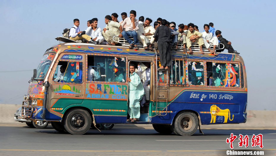 A Lahore, au Pakistan, un minibus est tellement rempli que les passagers sont obligés de monter sur le toit.
