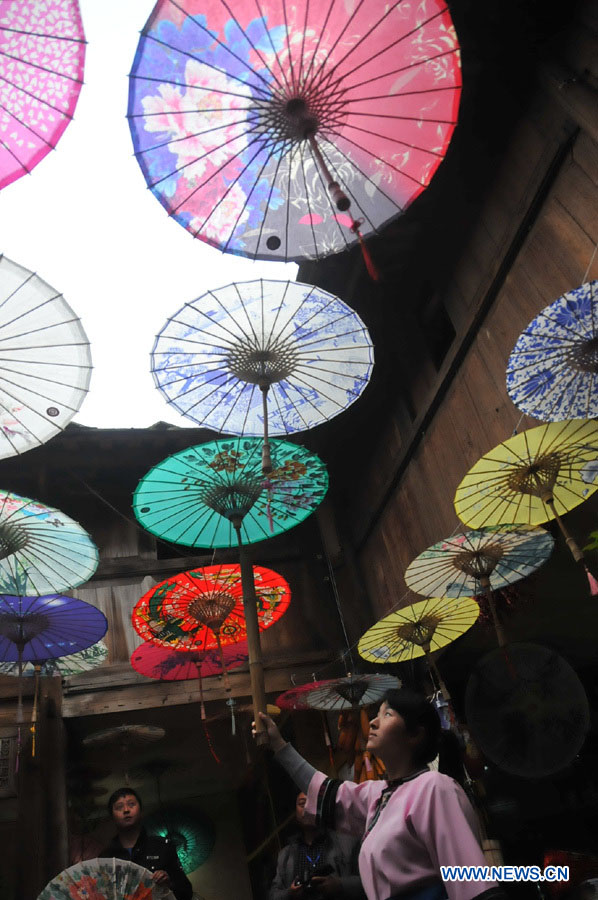 Une employée d'un atelier de parapluies de papier huilé du district de Xixiu, à Anshun, ville de la province du Guizhou (sud-ouest), le 12 novembre 2012. Fabriqué en papier huilé et doté d'une armature en bambou, ce type de parapluie est un objet artisanal traditionnel chinois. Les techniques de fabrication du parapluie de papier huilé ont été introduites au Guizhou durant la dynastie Ming. (Photo : Huang Yong)