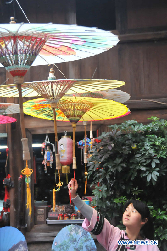 Une employée d'un atelier de parapluies de papier huilé du district de Xixiu, à Anshun, ville de la province du Guizhou (sud-ouest), le 12 novembre 2012. Fabriqué en papier huilé et doté d'une armature en bambou, ce type de parapluie est un objet artisanal traditionnel chinois. Les techniques de fabrication du parapluie de papier huilé ont été introduites au Guizhou durant la dynastie Ming. (Photo : Huang Yong)
