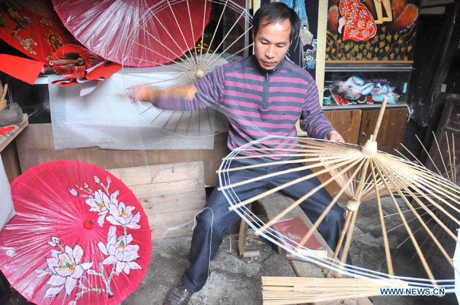 Un artisan fabrique des parapluies de papier huilé dans un atelier du district de Xixiu, à Anshun, ville de la province du Guizhou (sud-ouest), le 12 novembre 2012. Fabriqué en papier huilé et doté d'une armature en bambou, ce type de parapluie est un objet artisanal traditionnel chinois. Les techniques de fabrication du parapluie de papier huilé ont été introduites au Guizhou durant la dynastie Ming. (Photo : Huang Yong)