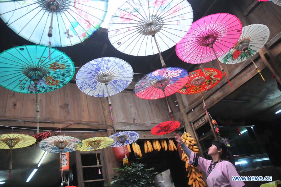 Une employée d'un atelier de parapluies de papier huilé du district de Xixiu, à Anshun, ville de la province du Guizhou (sud-ouest), le 12 novembre 2012. Fabriqué en papier huilé et doté d'une armature en bambou, ce type de parapluie est un objet artisanal traditionnel chinois. Les techniques de fabrication du parapluie de papier huilé ont été introduites au Guizhou durant la dynastie Ming. (Photo : Huang Yong)