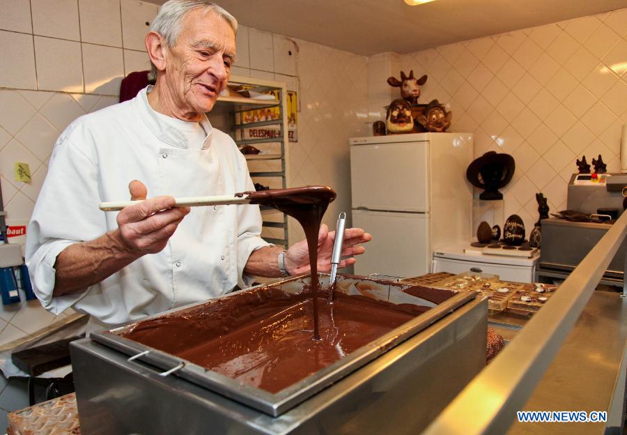 Un employé présente la confection de chocolats au Musée du cacao et du chocolat de Bruxelles, à l'occasion de la semaine du chocolat organisée dans la capitale belge, le 21 novembre 2012. (Photo : Yan Ting)