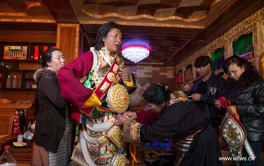 Des femmes ajustent le costume du marié Raidain Jamco (au centre), avant sa cérémonie de mariage dans la commune de Xiangbala du district de Xiangcheng, dans la province du Sichuan (sud-ouest), le 25 novembre 2012. 
