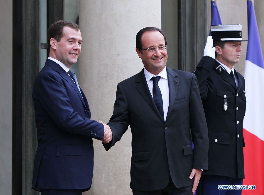 Le président français François Hollande (au centre) souhaite la bienvenue au Premier ministre russe Dmitri Medvedev avant leur rencontre à l'Elysée à Paris, le 27 novembre 2012.