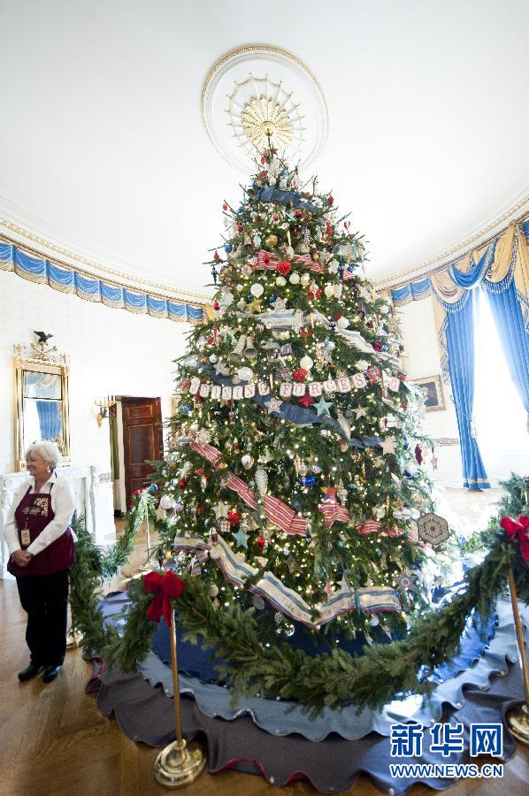 Le 28 novembre à la Maison Blanche, une volontaire à côté d'un sapin de Noël d'une hauteur de 5, 67 m.