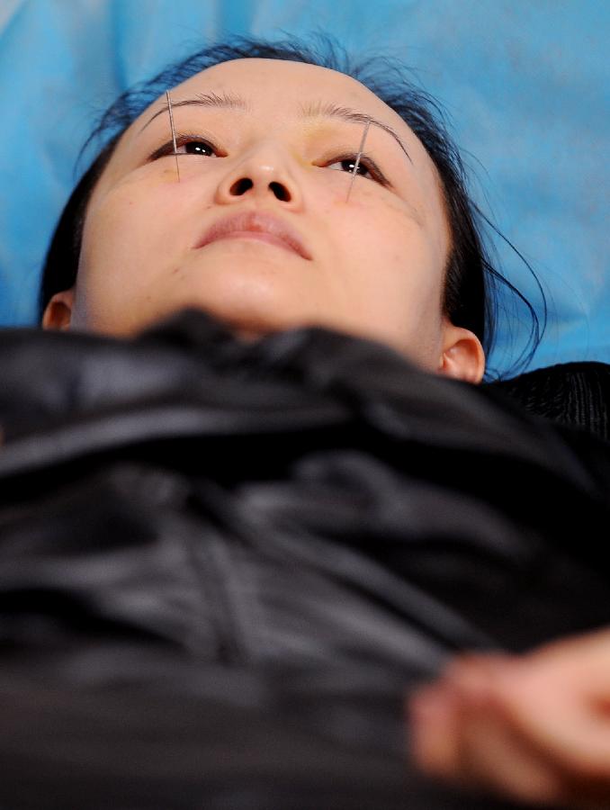 Une femme pendant une séance de traitement à la cire, à la Faculté de Médecine Traditionnelle Chinoise du Shanxi à Taiyuan, capitale de la Province du Shanxi, dans le Nord de la Chine, dans le Nord de la Chine, le 23 novembre 2012.