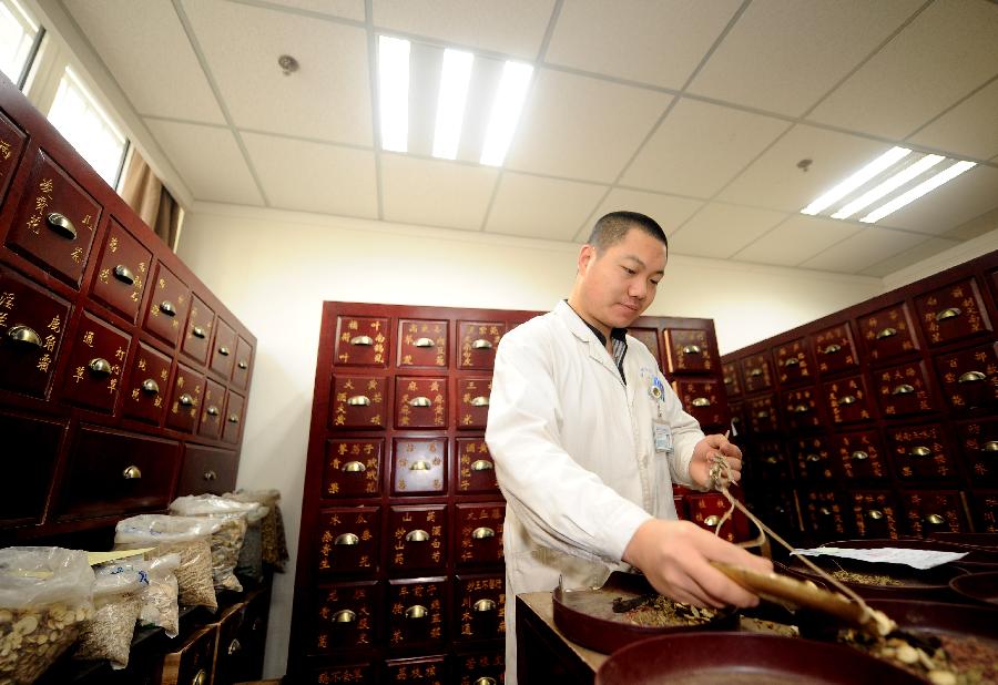 Un médecin de l’hôpital affilié à la Faculté de Médecine Traditionnelle Chinoise du Shanxi prépare des médicaments traditionnels chinois à base de plantes pour des patients à Taiyuan, capitale de la Province du Shanxi, dans le Nord de la Chine, le 23 novembre 2012.