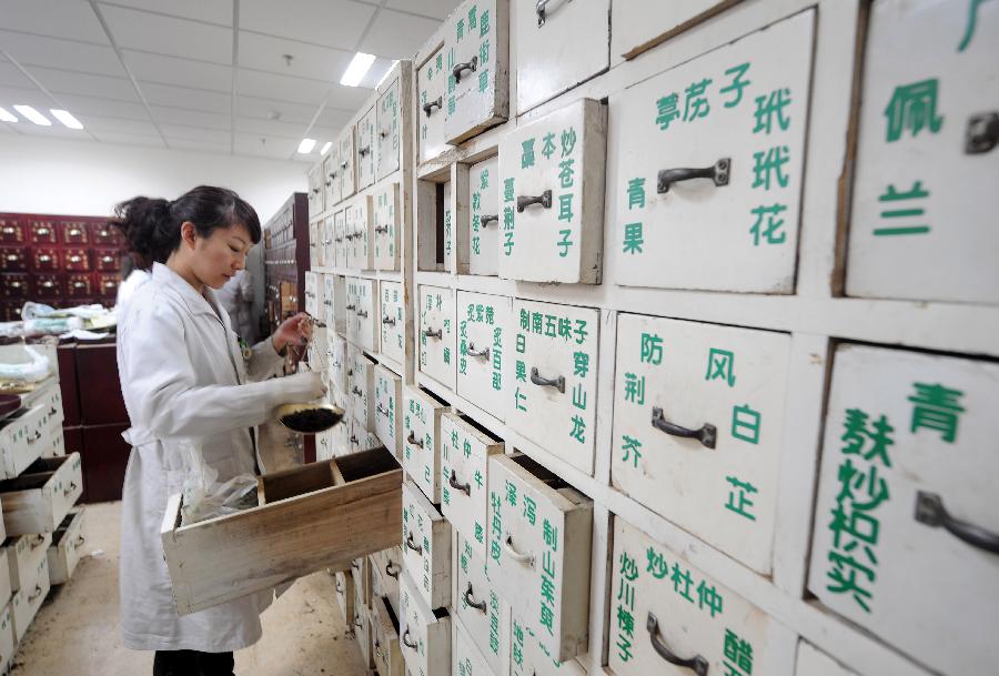 Un médecin de l’hôpital affilié à la Faculté de Médecine Traditionnelle Chinoise du Shanxi prépare des médicaments traditionnels chinois à base de plantes pour des patients à Taiyuan, capitale de la Province du Shanxi, dans le Nord de la Chine, le 23 novembre 2012.