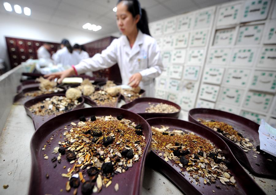 Un médecin de l’hôpital affilié à la Faculté de Médecine Traditionnelle Chinoise du Shanxi prépare des médicaments traditionnels chinois à base de plantes pour des patients à Taiyuan, capitale de la Province du Shanxi, dans le Nord de la Chine, le 23 novembre 2012.