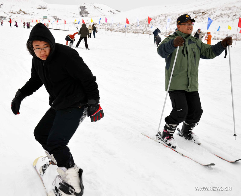 Des touristes skient sur le site touristique de Tianchi dans les monts Tianshan, dans la région autonome ouïgoure du Xinjiang (nord-ouest), le 1er décembre 2012. Le Festival de glace et de neige de Tianchi a ouvert samedi sur ce site touristique.(Photo : Yu Tao)
