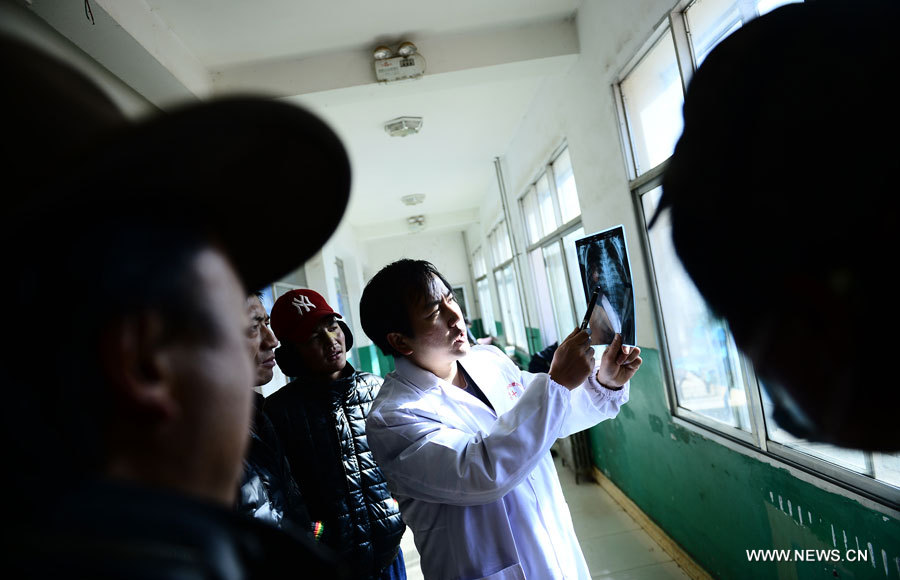 Le médecin Zhang Lu (premier à droite) de l'Hôpital cardiovasculaire de la Croix rouge de l'Anhui examine la radio d'un enfant souffrant d'une maladie cardiaque congénitale, dans le district de Nangqian de la province du Qinghai (nord-ouest), le 3 décembre 2012.