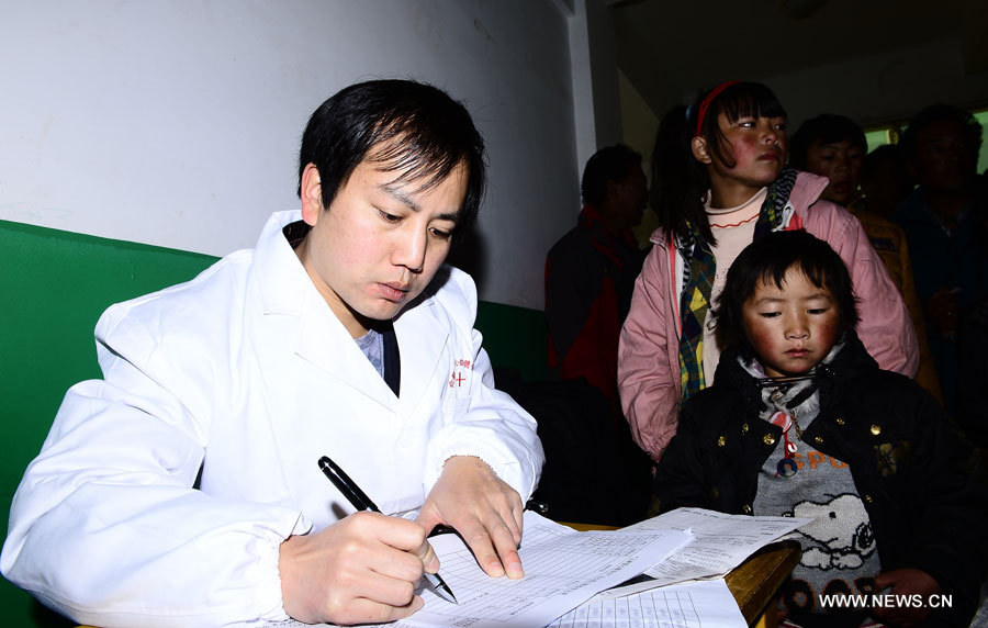 Le médecin Zhang Lu de l'Hôpital cardiovasculaire de la Croix rouge de l'Anhui note l'état de santé d'un enfant, dans le district de Nangqian de la province du Qinghai (nord-ouest), le 3 décembre 2012. 