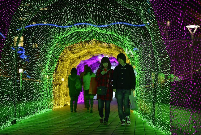 Le 21 novembre, deux amies traversent un passage couvert d'illuminations lors de la foire des illuminations de Noël à Tokyo.