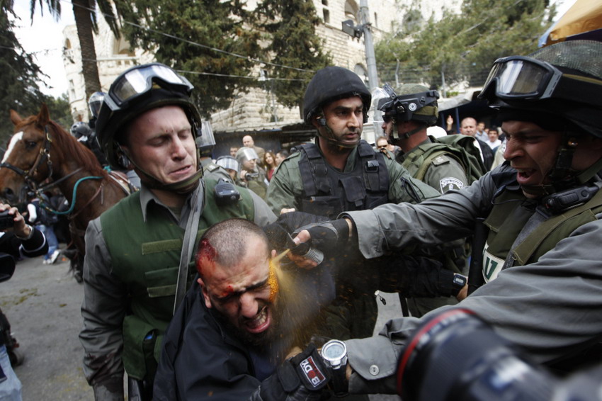 Le 30 mars 2012 à Jérusalem, un policier arrose de gaz poivre le visage d'un manifestant palestinien lors d'un conflit entre les manifestants et les forces de l'ordre. REUTERS / Ammar Awad