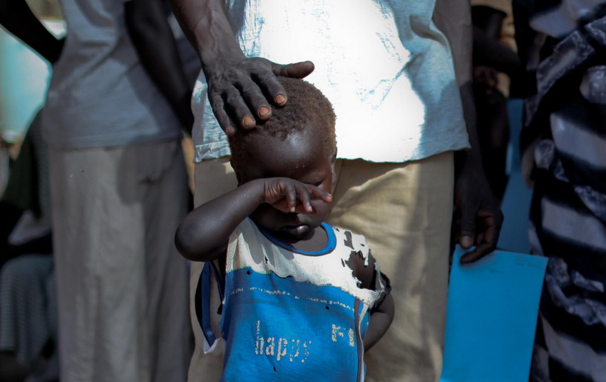 Le 9 mars 2012 dans un camp de réfugiés au Soudan, un garçon qui a traversé les frontières de l'Etat du Nil Bleu du Soudan pour fuir la guerre attend en dehors d'une clinique. REUTERS/Hereward Holland