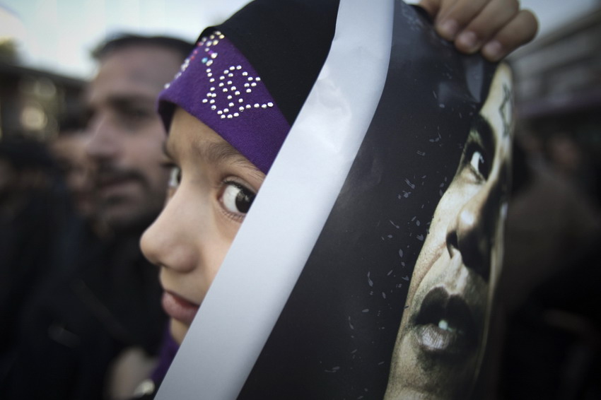 Le 13 janvier 2012 à Téhéran, une jeune iranienne, brandit une affiche anti-américaine sur laquelle se trouve le visage de Brack Obama, participe aux furénailles du scientifique iranien du nucléaire Mostafa Ahmadi-Roshan. REUTERS/Morteza Nikoubazl
