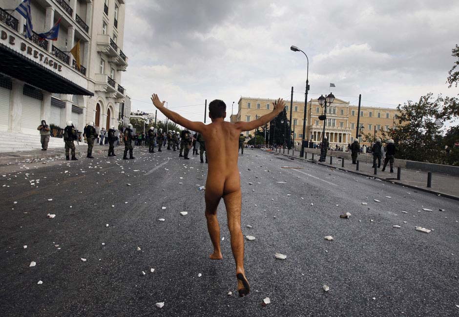 Le 9 octobre 2012 sur la place de Syntagma à Athène en Grèce, un protestant nu court en en direction du parlement grec lors d'une manifestation contre la visite de la chancelière allemande Angela Merkel. REUTERS / John Kolesidis