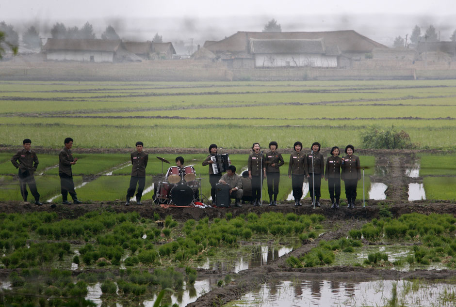 Le 6 juin 2012 sur l'île de Hwanggumpyong en Corée du Nord, située aux frontières avec la Chine, un groupe musical en représentation dans la campagne pour saluer les paysans. REUTERS / Jacky Chen
