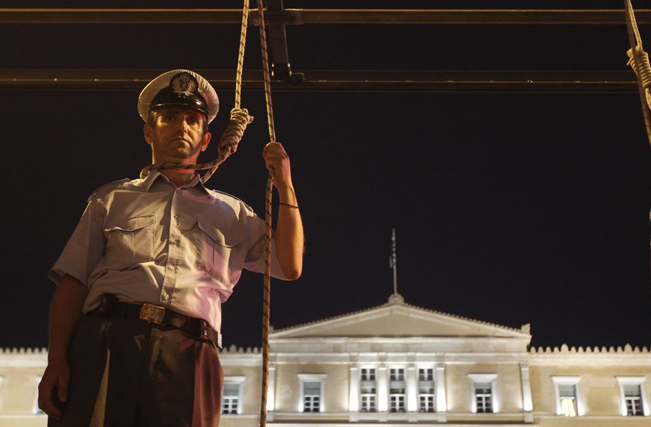 Le 6 septembre 2012 à Athènes, un agent de police mimant une pendaison devant la parlement durant un rassemblement dans la capitale. REUTERS / John Kolesidis
