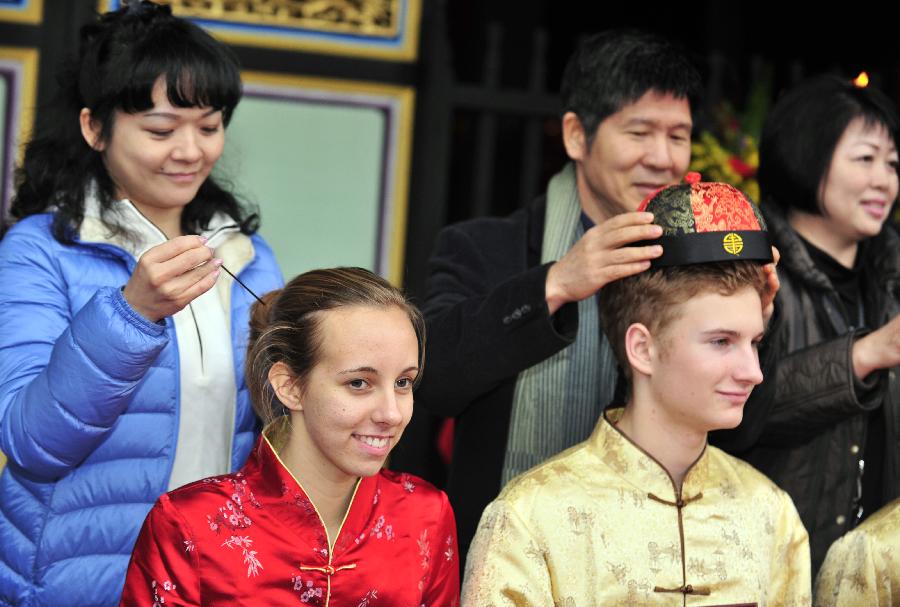 Deux étudiants, en plein rituel, l'épingle dans les cheveux pour la jeune fille et la coiffe du traditionnel chapeau chinois pour le garçon, lors de leur cérémonie du passage à la majorité qui a été organisée, dimanche 9 décembre 2012, dans le Temple de Confucius à Taipei, capitale de la province de Taïwan en Chine. (Xinhua/Wu Ching-teng)