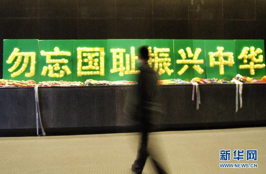 Le 11 décembre 2012, un homme passe devant des plaques fixées au mur du Mémorial du massacre de Nanjing, sur lesquelles nous pouvons lire « N'oublions pas cette honte nationale et redressons la nation chinoise. » (Photo : Xinhua / Dong Jinlin)