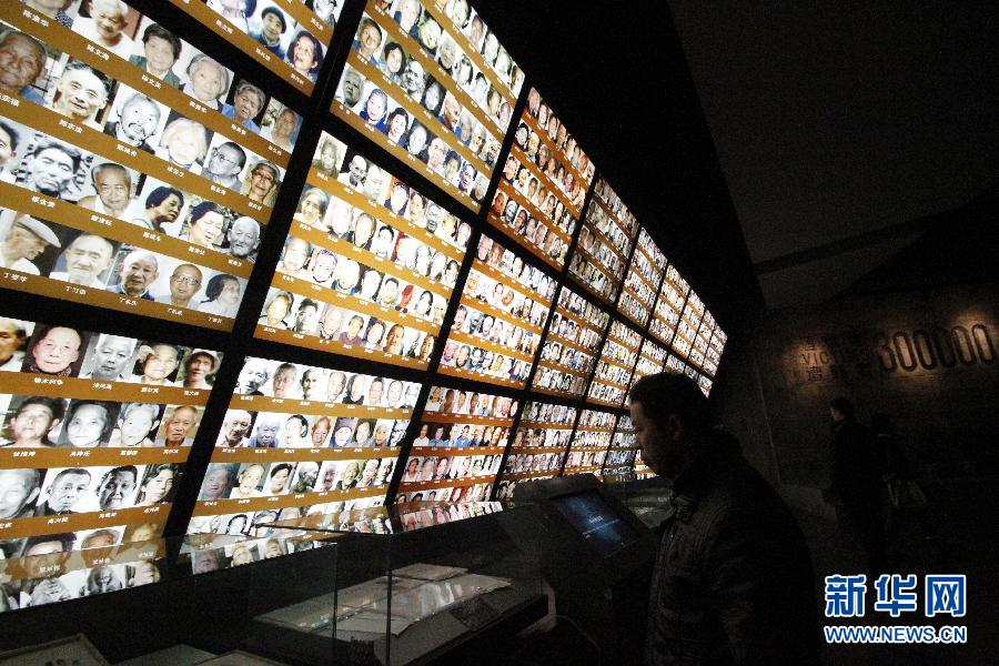 Le 11 décembre dans le Mémorial du massacre de Nanjing, des visiteurs devants les photos des survivants de ce crime atroce commis par les Japonais. (Photo : Xinhua / Dong Jinlin)