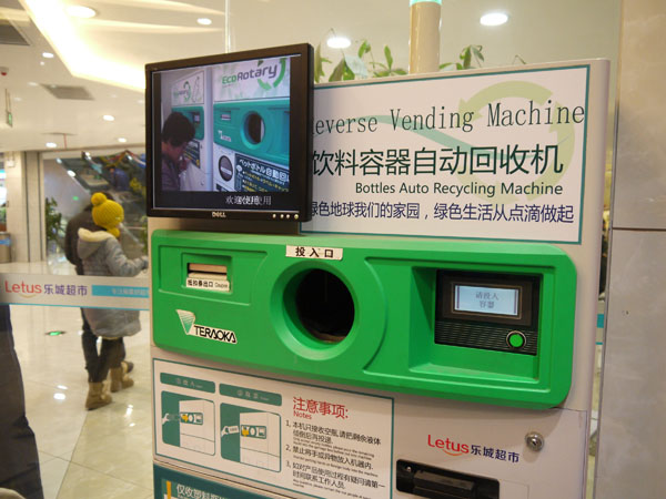 Les clients peuvent recycler des bouteilles usagées grâce à une machine de recyclage se situant à l'intérieur du premier supermarché chinois high-tech, à Hefei, capitale de la province d'Anhui (est de la Chine), le 10 décembre 2012.