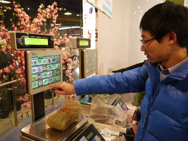 Un client utilise un distributeur en libre-service dans le premier supermarché chinois du futur, à Hefei, la capitale de la province d'Anhui à l'est de la Chine, le 10 décembre 2012.