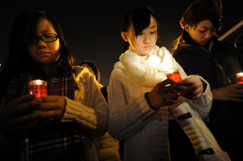 Le 12 décembre, des représentants des étudiants de Hong Kong, tiennent chacun une bougie allumées, pour participee à la veillée commémorative pour les victimes. (Xinhua / Han Yuqing)