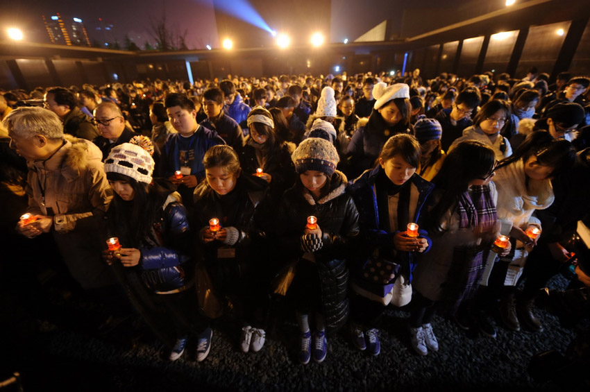Le 12 décembre, chacun tient une bougie pour participer à une veillée organisée pour commémorer les compatriotes tués dans le massacre. (Xinhua / Sun Can)