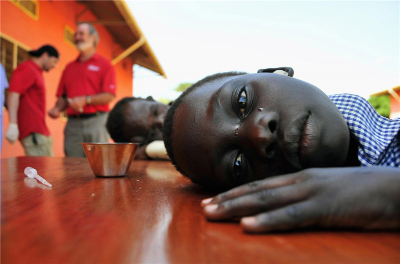 Une jeune fille équipée de prothèses auditives pleure après que ses oreilles aient été nettoyées lors d'une manifestation organisée par la Starkey Hearing Foundation à St. Monica, à Gulu, à 364 km au nord de la capitale de l'Ouganda, Kampala, le 13 mars 2012.