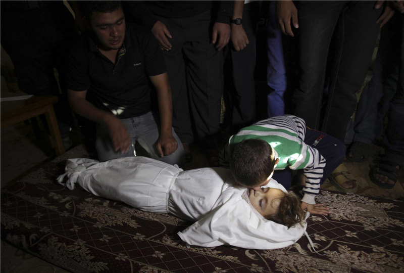 Le frère du jeune palestinien Walid al-Abadlah, qui, selon des responsables hospitaliers a été tué lors d’un raid aérien israélien, embrasse son corps lors de ses funérailles à Khan Younis dans le sud de la bande de Gaza, le 15 novembre 2012.