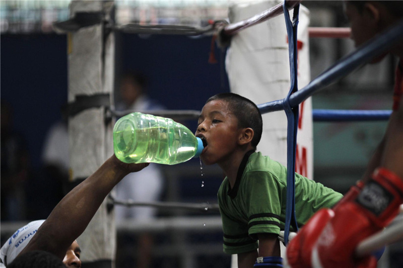 Ulises, 8 ans, boit de l'eau lors d'une séance d'entraînement au gymnase Rockero Alcazar dans le quartier à faibles revenus de Curundu, à Panama City, le 3 mai 2012. Cette salle de fitness a été baptisée du nom du boxeur et champion panaméen super-poids mouche WBO Pedro Rockero Alcazar, décédé en 2002. La salle de sport possède des formateurs de boxe bénévoles et l'adhésion y est gratuite.