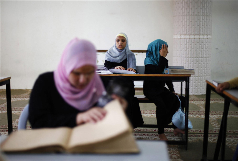 Une jeune palestinienne atteinte de graves problèmes de vue lit une version en braille du Coran lors d'une leçon sur la mémorisation du Coran dans la ville de Gaza, le 12 juillet 2012. Des dizaines de jeunes palestiniennes aveugles et malvoyantes ont pris part à cette leçon parrainée par l'organisation musulmane Société Dar al-Quran, dont le but affiché est d'enseigner aux gens le livre saint des musulmans.