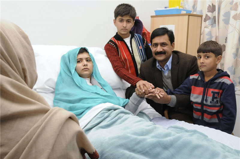 Malala Yousufzai avec son père Ziauddin et ses deux jeunes frères Khushal Khan et Khan Atal (à droite), alors qu'elle récupère à l'hôpital de La Reine Elizabeth à Birmingham ; photo prise le 25 octobre 2012 et publiée le 26 octobre 2012.