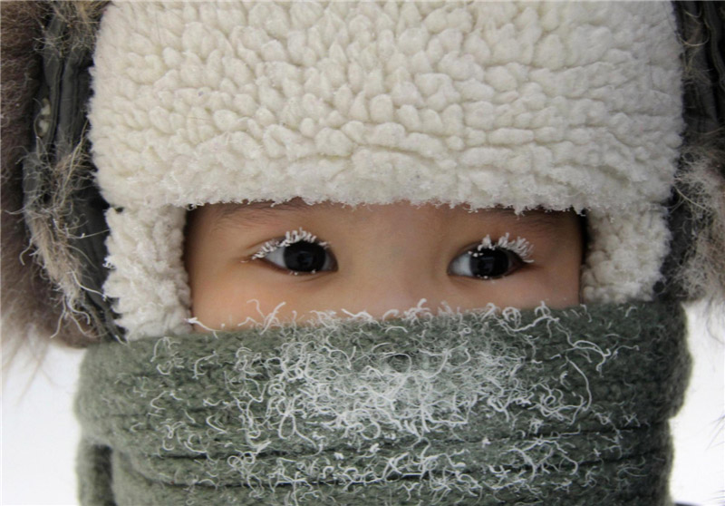 Un enfant, avec les cils recouverts de givre, aperçu dans une rue de la ville de Yakutsk dans la République de Sakha (Iakoutie), dans l'Est de la Sibérie, le 10 février 2012.