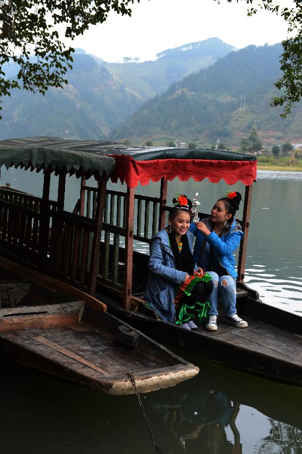 Le 18 décembre dans le district Rongjiang du Guizhou en Chine, deux jeunes filles de l'ethnie Dong prennent le bateau pour aller participer à la fête du Sama. (Xinhua/Peng Nian)