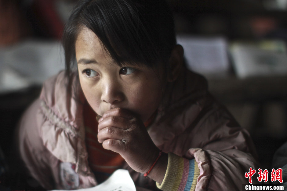 Cette fille est nommée Xiong Shouhui. Son père travaille à Guiyang, capitale de la province du Guizhou, depuis huit mois. Mais ce qu'il gagne ne suiffit qu'à ses propres besoins. La petite n'a qu'une veste courte qu'elle porte pour se protéger contre le froid en hiver. Elle souffre déjà d'une gelure aux mains. (Chinanews/Feng Zhonghao)