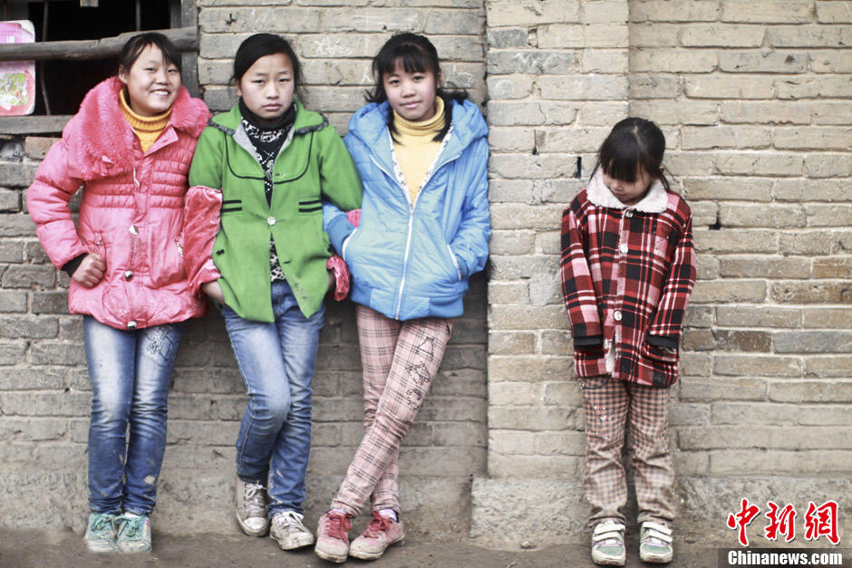 Trois filles de la 6e année et une de la 3 année devant les salles de classes. Dans leur école, il n'y a qu'un seul professeur, Tao Jinjun, un diplômé du college, puisque personne d'autre ne veut y enseigner. (Chinanews/Feng Zhonghao)
