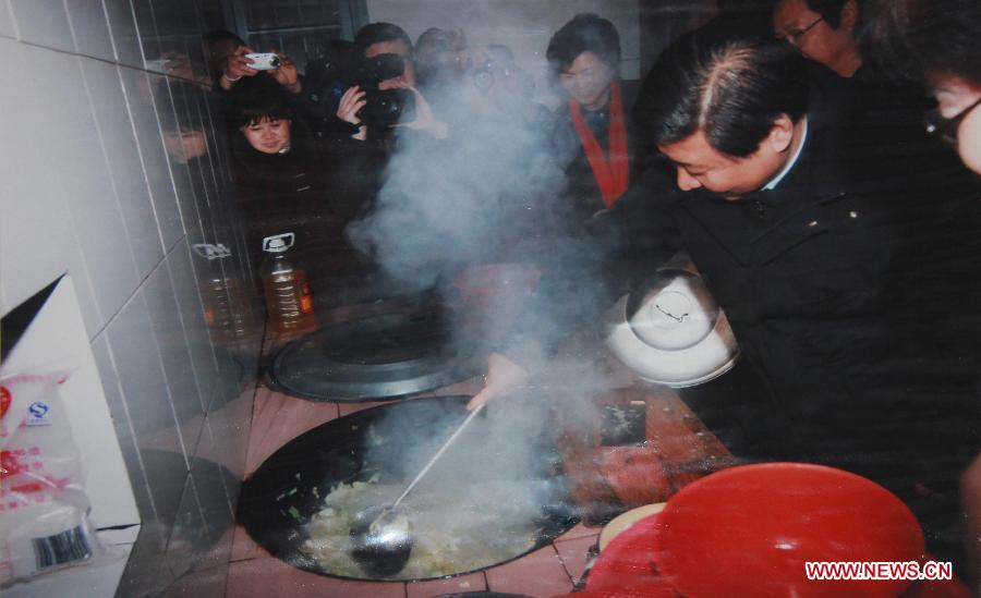 Photo d'archive prise en janvier 2007 montrant Xi Jinping (1er à droite), alors qu'il était secrétaire du Comité du Parti communiste chinois (PCC) pour la province du Zhejiang, cuisinant pour les personnes âgées dans un foyer de retraités dans le bourg de Pingdu du district de Qingyuan, dans la province du Zhejiang (est), en Chine.