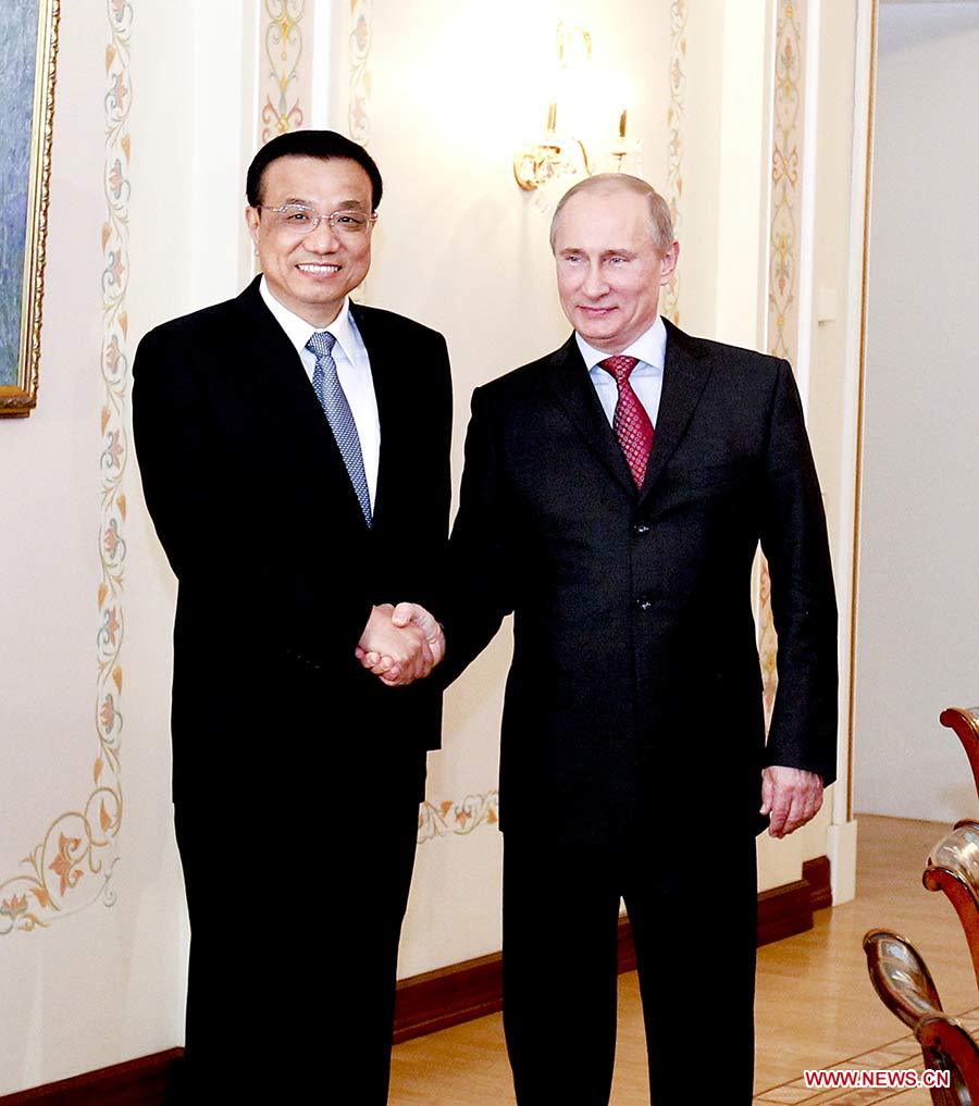 Photo d'archive prise le 27 avril 2012 montrant la poignée de main entre Li Keqiang (à gauche) et le président russe Vladimir Poutine à Beijing, en Chine.