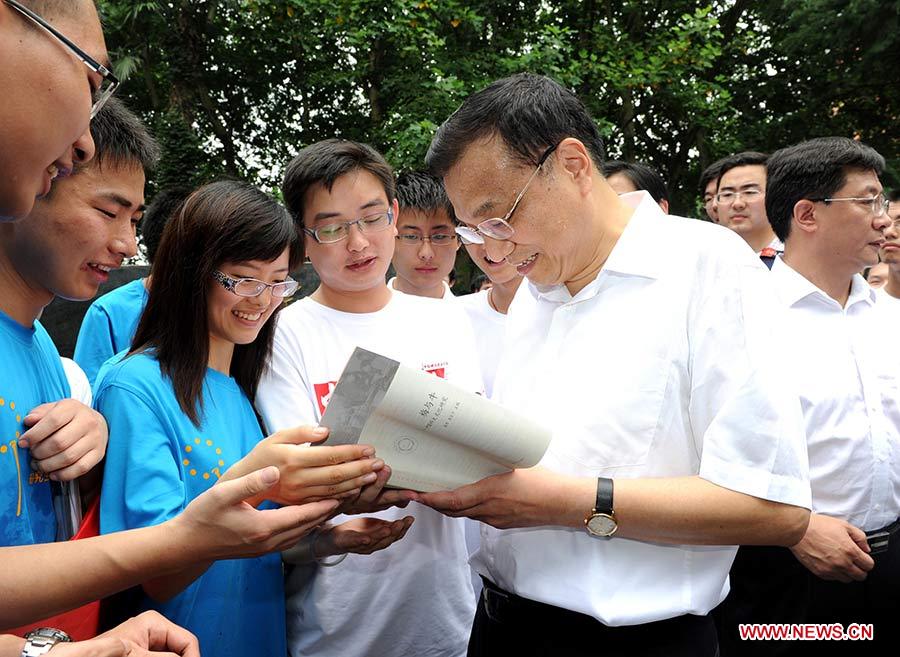 Photo prise le 5 juillet 2011 montrant Li Keqiang (1er à droite au premier plan) parlant avec des étudiants de l'Université des sciences et technologies de Chine lors de son inspection sur le développement social et économique dans la province centrale de l'Anhui, en Chine.