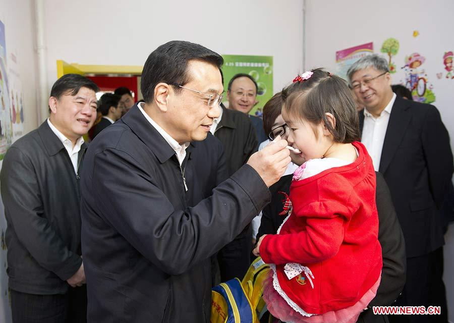 Photo d'archive prise le 25 avril 2011 montrant Li Keqiang lors des activités de la Journée nationale de la vaccination préventive dans le centre de santé du quartier de Fangzhuang à Beijing, en Chine.