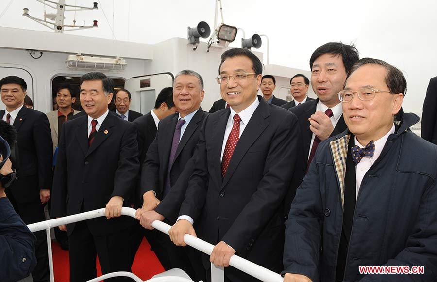 Photo d'archive prise le 15 décembre 2009 montrant Li Keqiang (3e à droite) à bord d'un bateau, pour aller voir le chantier en mer du pont Hong Kong - Zhuhai - Macao après avoir participé à la cérémonie de lancement des travaux du pont à Zhuhai, dans la province du Guangdong (sud), en Chine.