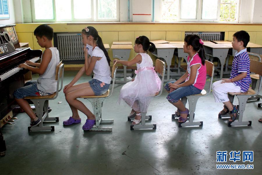 A Hefei, dans la province de l'Anhui, plusieurs enfants font la queue pour pratiquer le piano avant leur examen, le 4 août 2012.